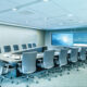 A modern collaboration space with a U-shaped table, multiple displays, and an advanced videoconferencing setup.