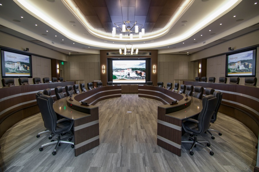 A large conference room featuring an elaborate AV system with multiple screens.